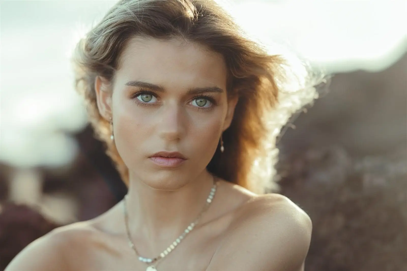 A soft, bronzed natural look with loose waves, shot outdoors