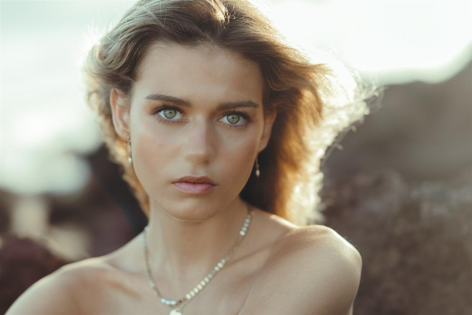 A soft, bronzed natural look with loose waves, shot outdoors